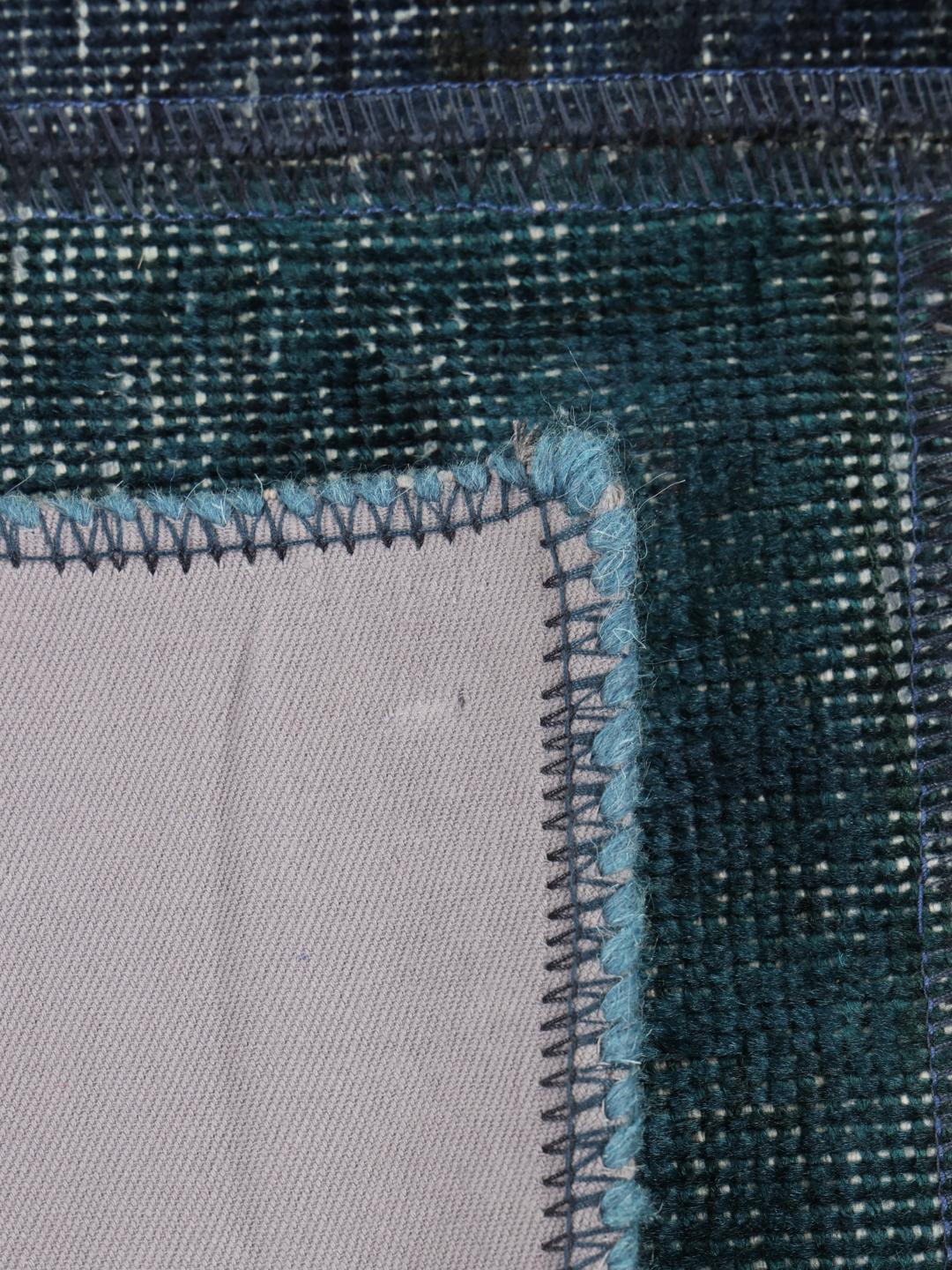Et kvadratisk patchworktæppe med forskellige nuancer af dybblå fra Mellemøsten.