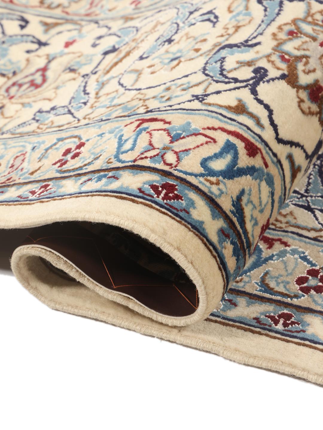 A large, rectangular Nain 9La rug with intricate blue and red floral patterns on a beige field, originating from the Middle East.