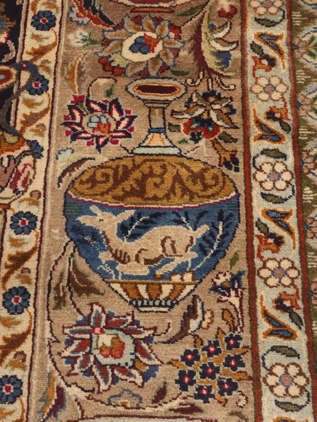 Een groot, handgeknoopt Kashmar-tapijt uit het Midden-Oosten met een donkerblauw veld en sierlijke florale en picturale ontwerpen.