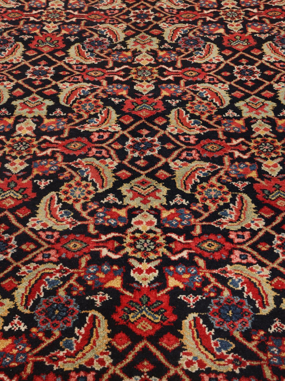 Hand-knotted Sarouk rug from the Middle East in dark-red and blue tones.