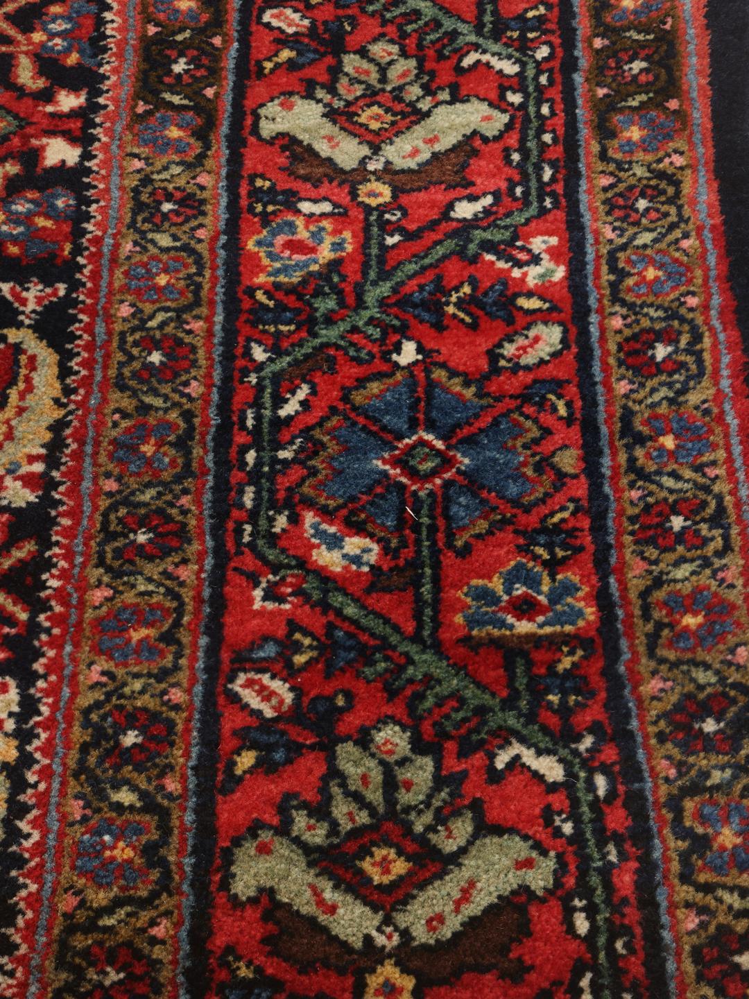 Hand-knotted Sarouk rug from the Middle East in dark-red and blue tones.