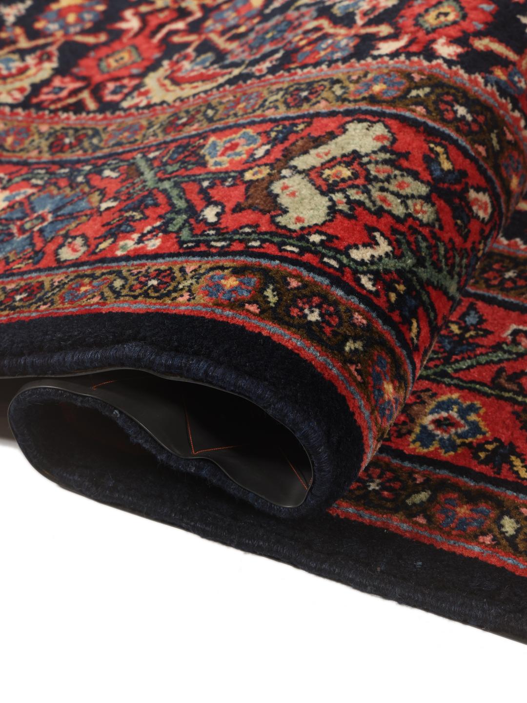 Hand-knotted Sarouk rug from the Middle East in dark-red and blue tones.