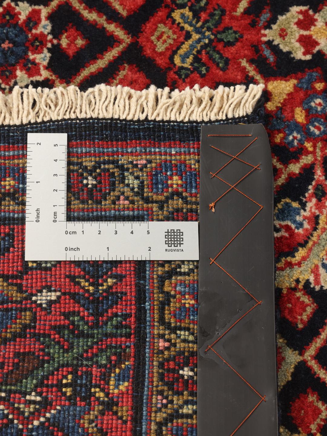 Hand-knotted Sarouk rug from the Middle East in dark-red and blue tones.