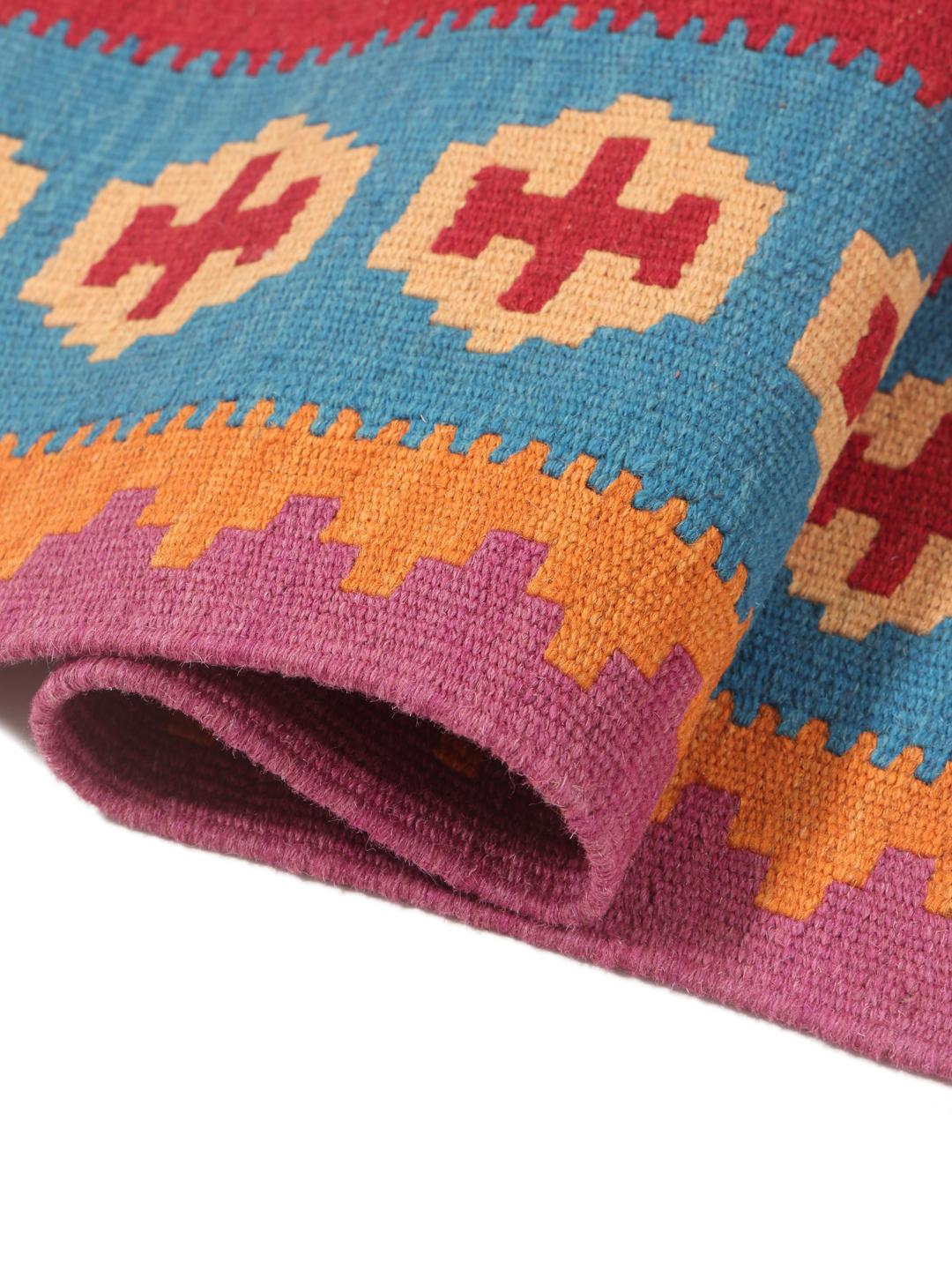 A hand-woven Kelim Ghashghai rug from the Middle East with a vibrant multicolor geometric pattern.