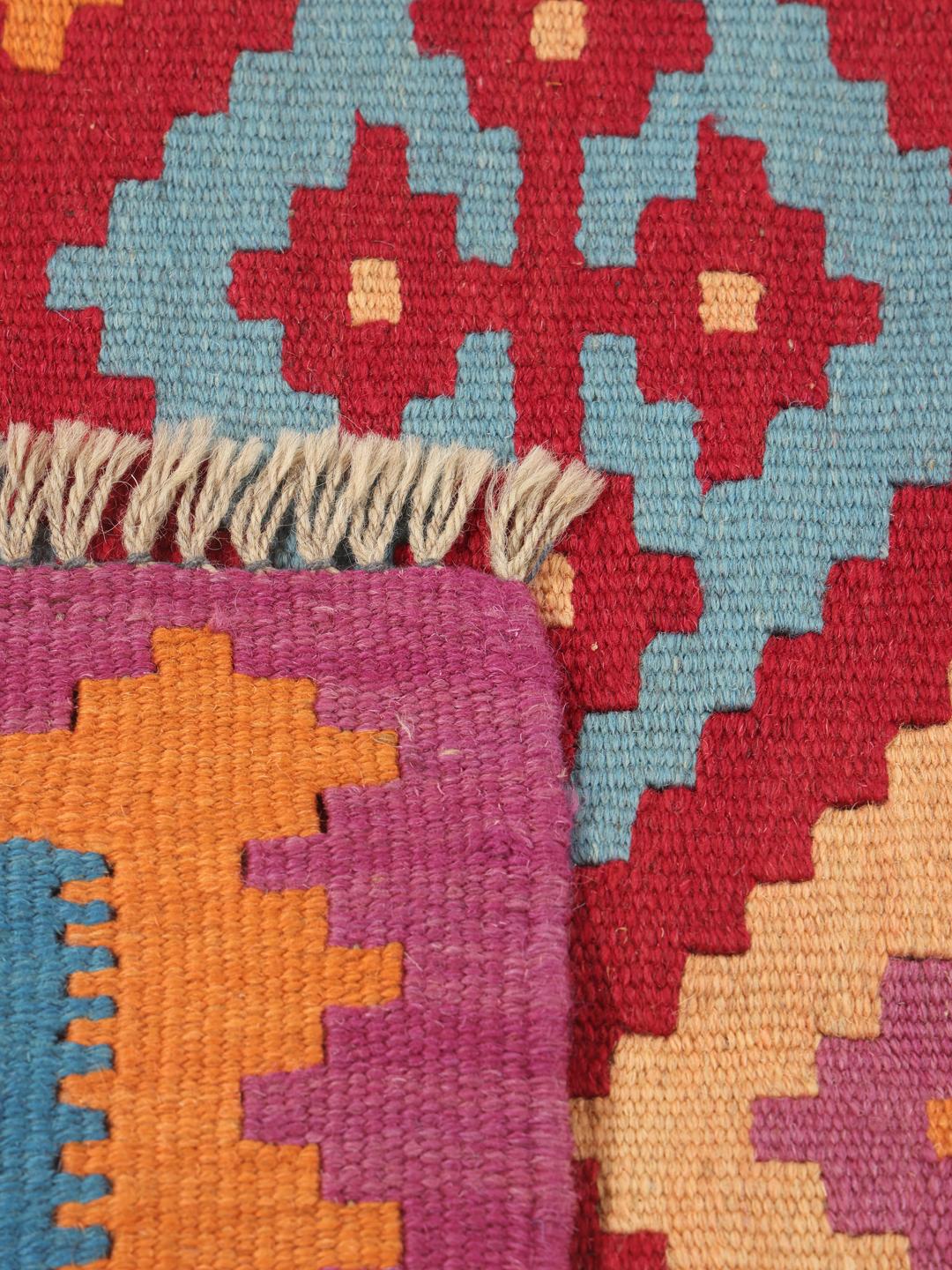 A hand-woven Kelim Ghashghai rug from the Middle East with a vibrant multicolor geometric pattern.