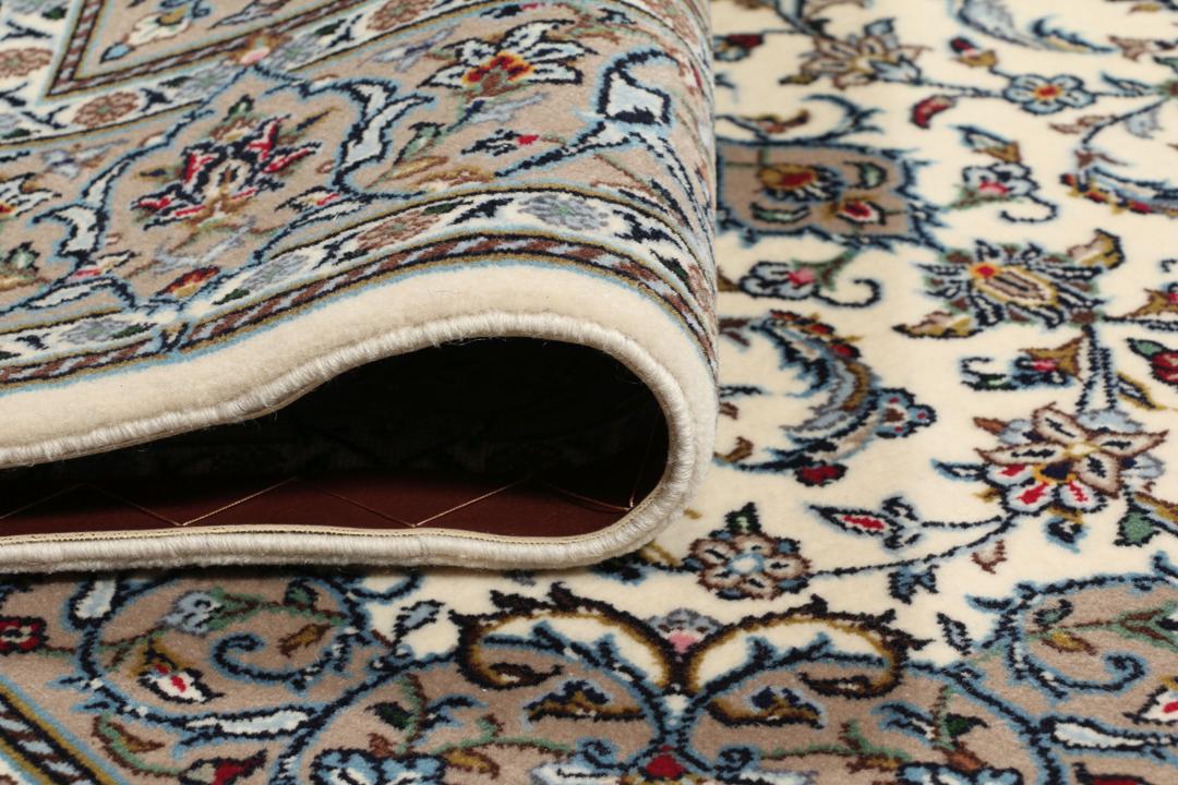 Un tapis Keshan noué main provenant du Moyen-Orient avec un médaillon floral beige et bleu.