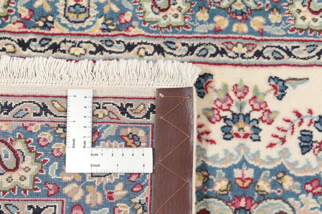 Et rektangulært Kerman-tæppe fra Mellemøsten med et blomstret medaljonmønster i flerfarvede nuancer.