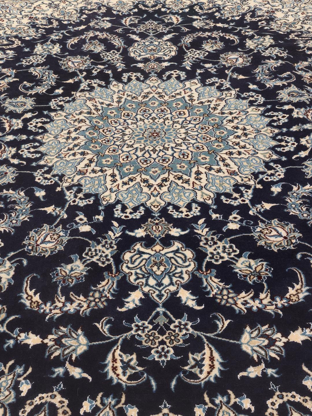 Hand-knotted Middle Eastern Nain rug featuring a dark-blue field with intricate floral patterns.
