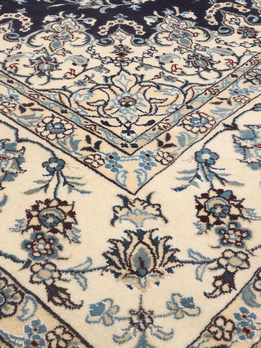 Hand-knotted Middle Eastern Nain rug featuring a dark-blue field with intricate floral patterns.
