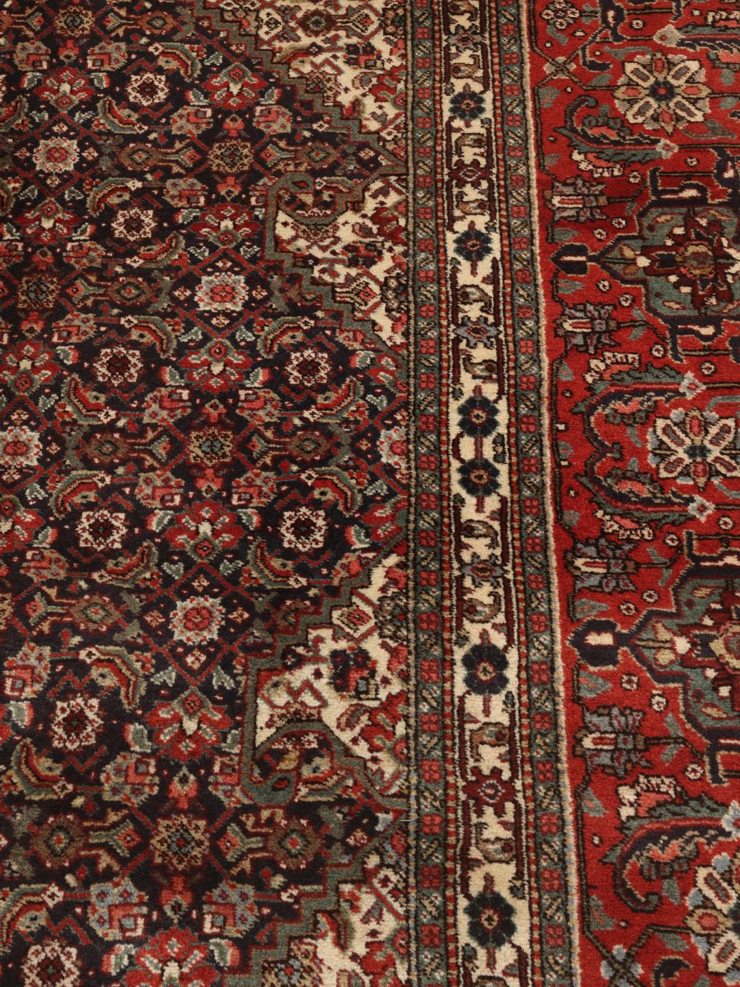 Een handgeknoopt Tabriz 40 Raj tapijt uit het Midden-Oosten in rood- en beige tinten.