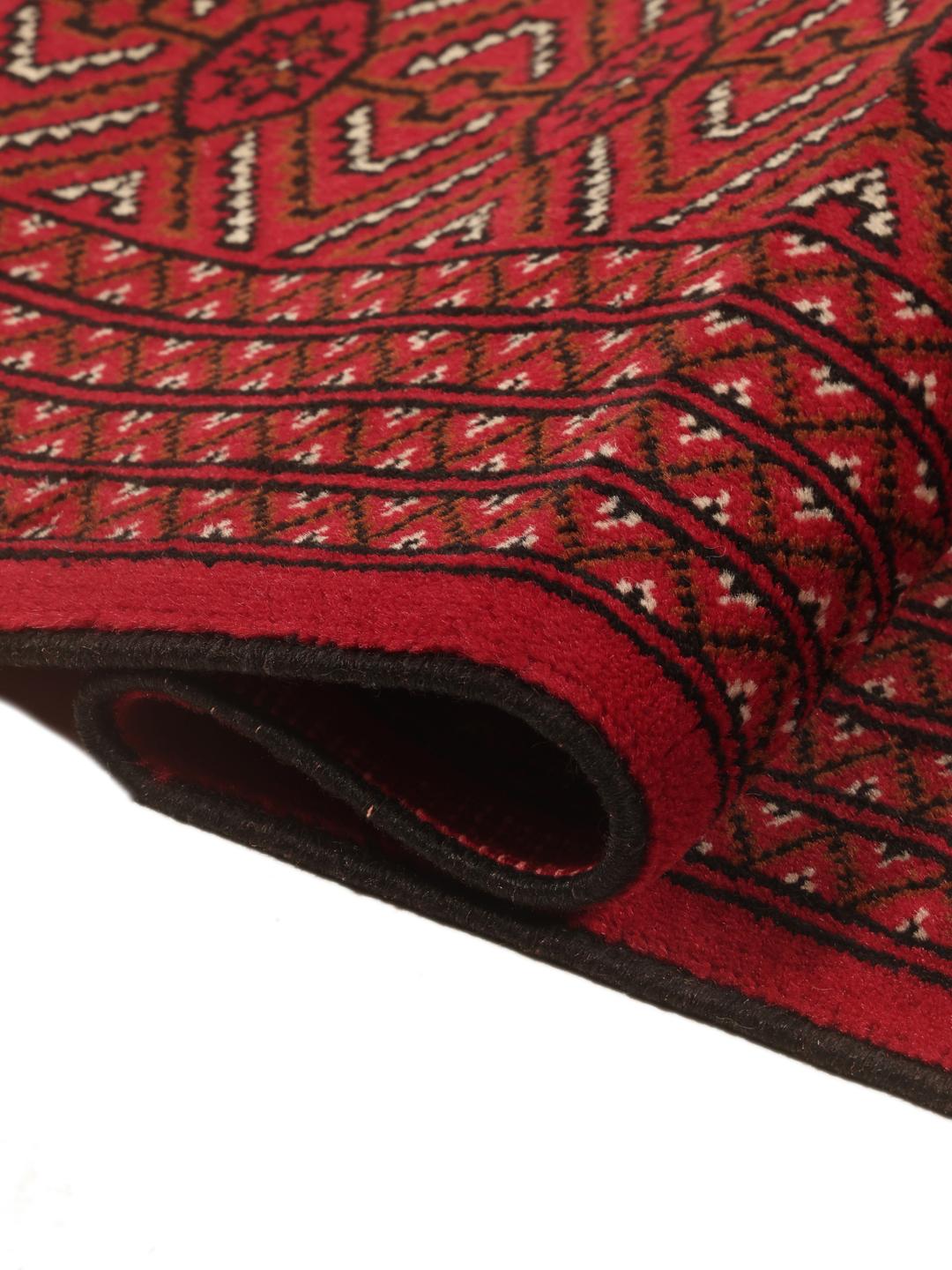 A hand-knotted Turkaman rug from the Middle East in deep red featuring geometric patterns