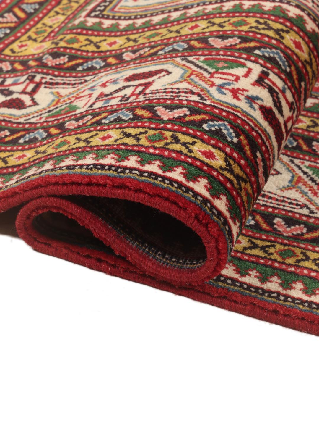 A large, hand-knotted Sarough Mir rug with a vibrant red field and geometric motifs.