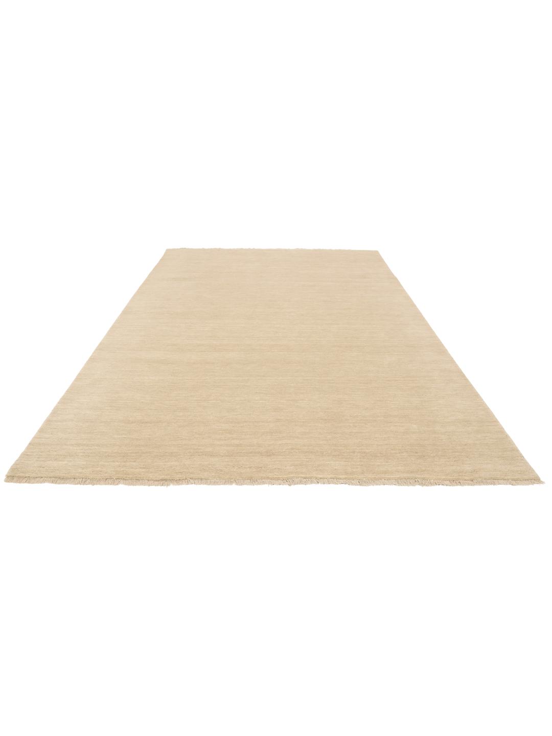 Een eenkleurig beige vloerkleed met verfijnde franjes