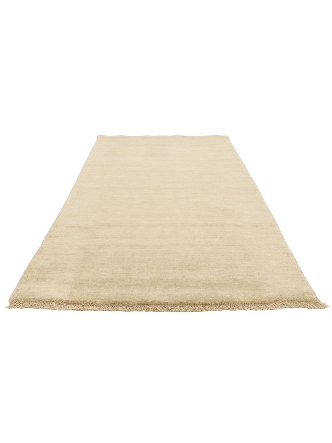 Een beige loper in één kleur met korte bijpassende franjes op een effen achtergrond