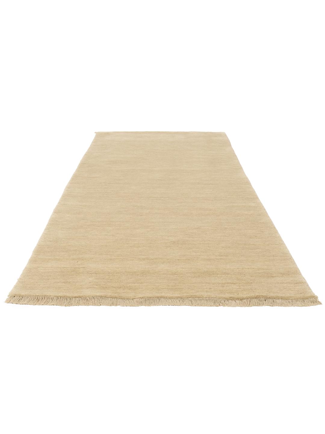 Een beige loper in één kleur met korte bijpassende franjes op een effen achtergrond