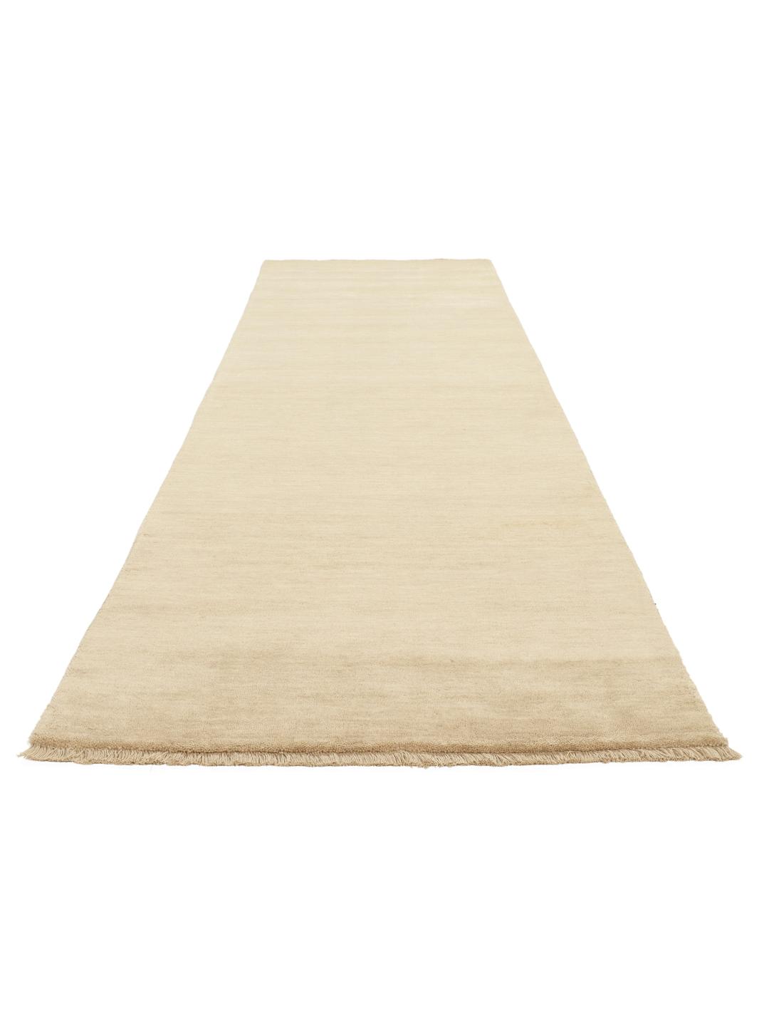 En ensfarvet beige løber med korte matchende frynser på en neutral baggrund