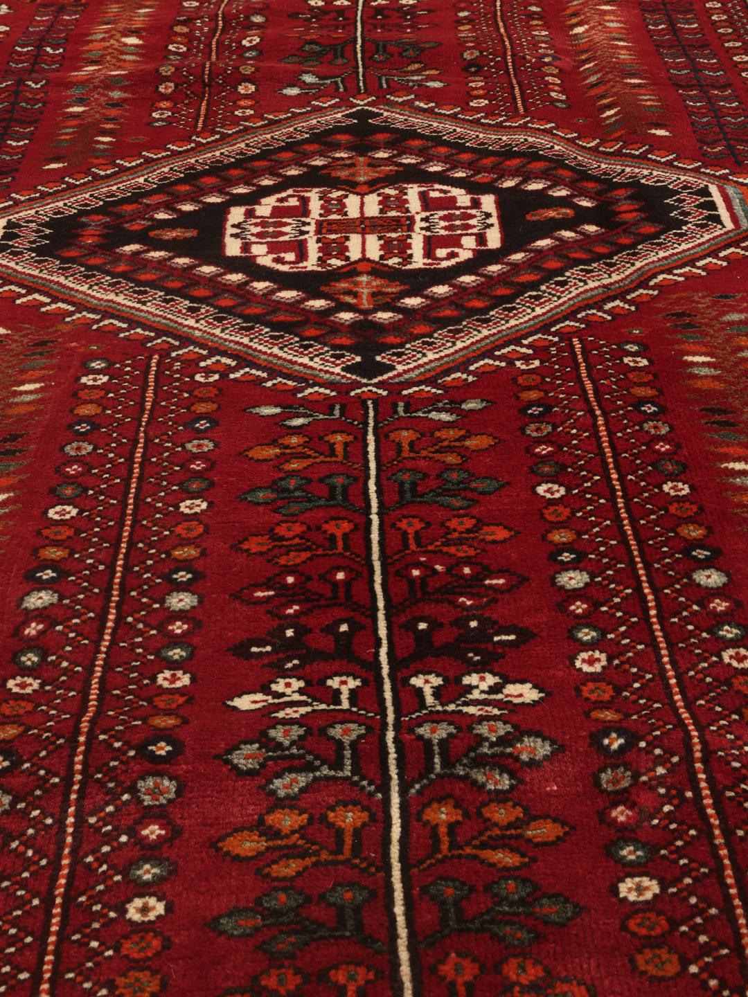 Hand-knotted Qashqai rug with traditional tribal patterns in red and dark tones