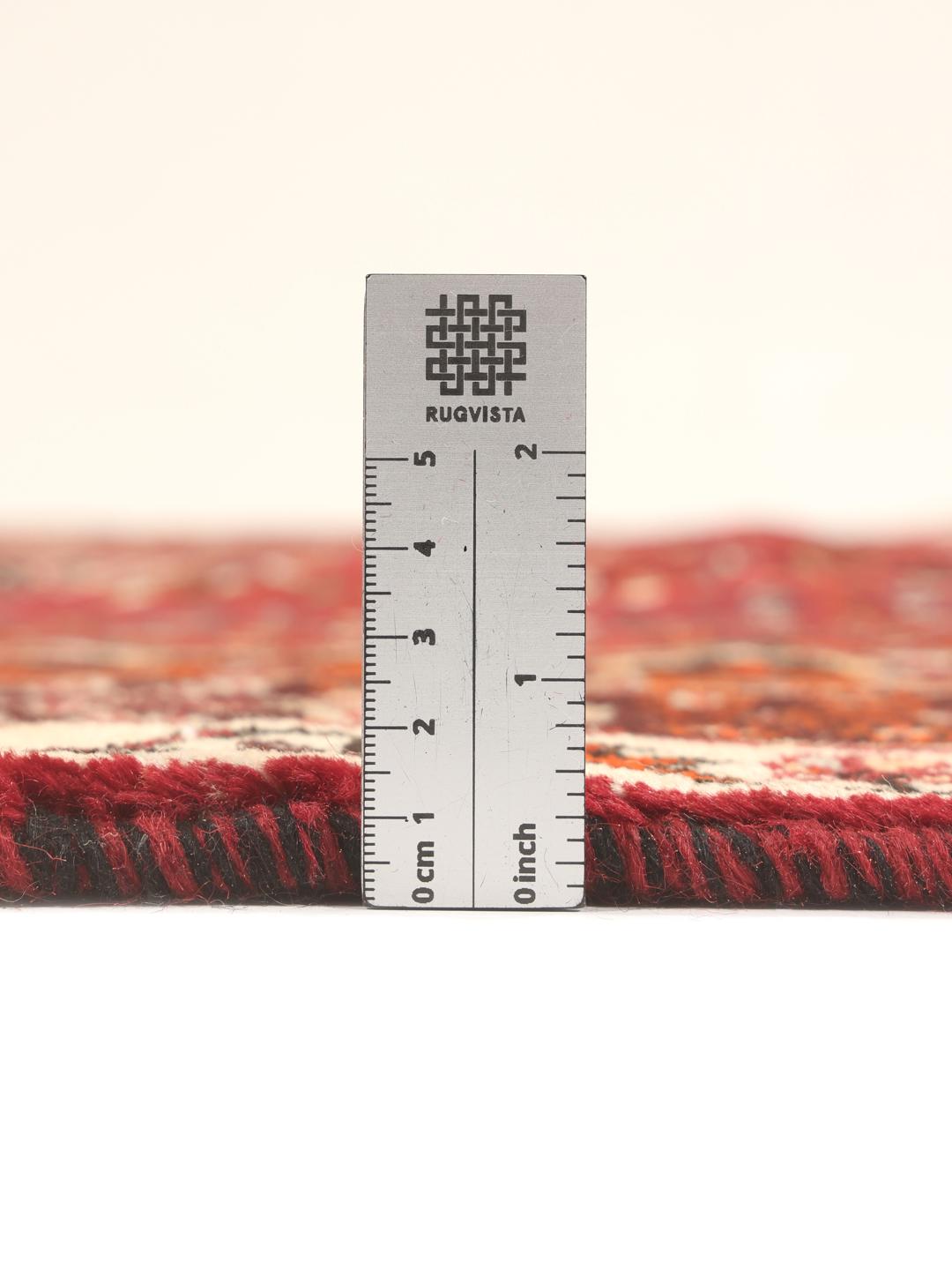 Hand-knotted Qashqai rug with traditional tribal patterns in red and dark tones