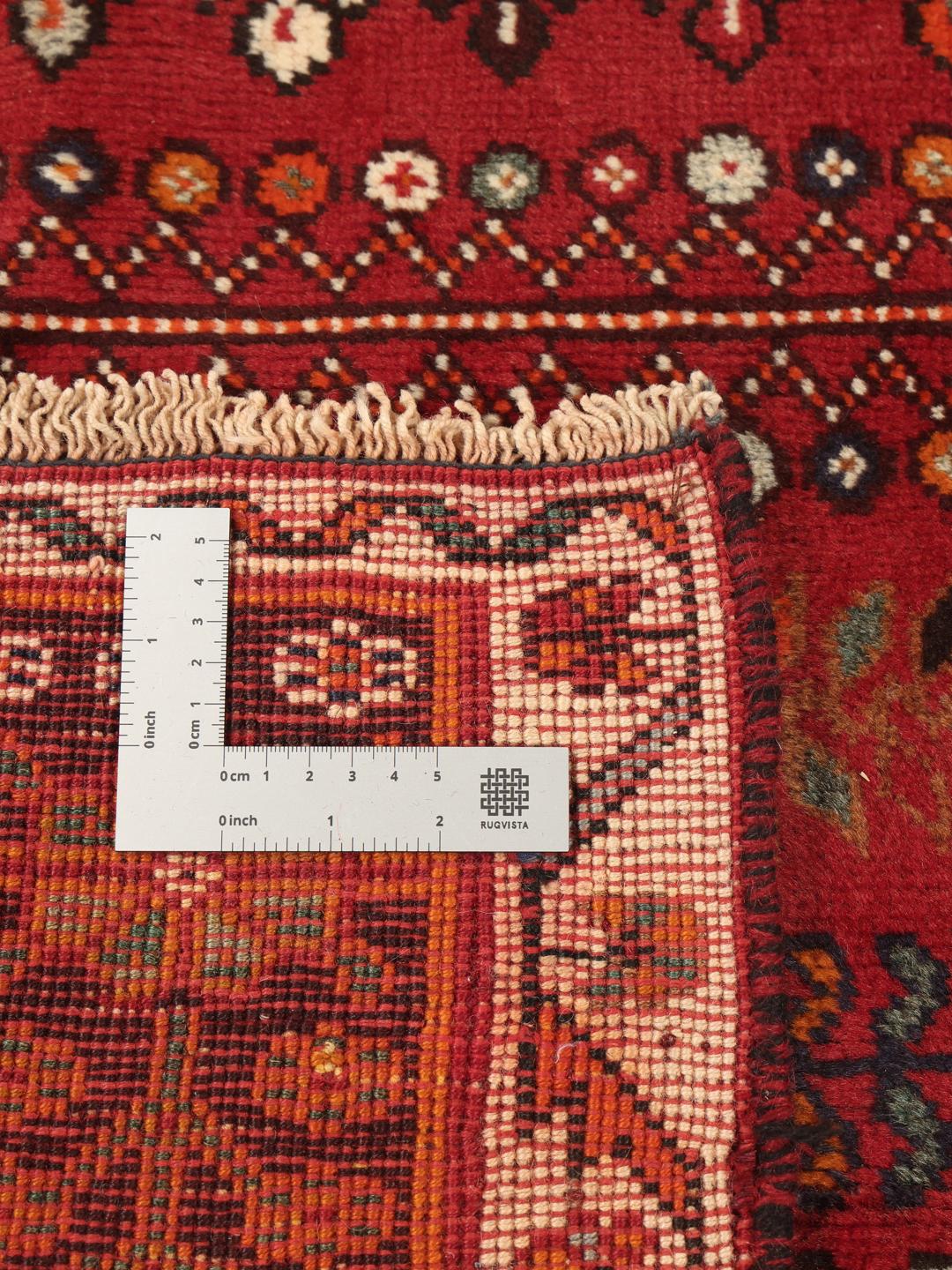 Hand-knotted Qashqai rug with traditional tribal patterns in red and dark tones