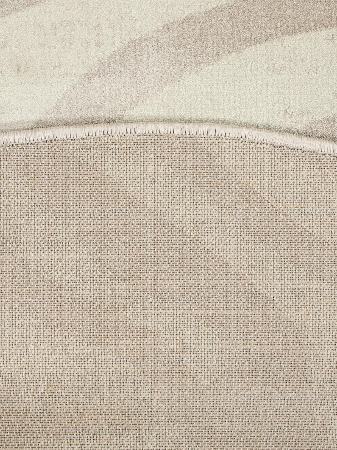 Cirkulært beige tæppe med et diskret zebramønster