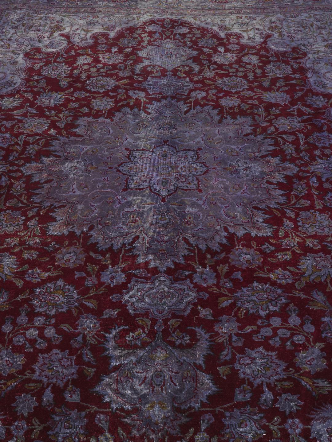 Ručno čvorani tepih s Bliskog istoka u tamnocrvenim i ljubičastim tonovima s tradicionalnim cvjetnim medaljonom.