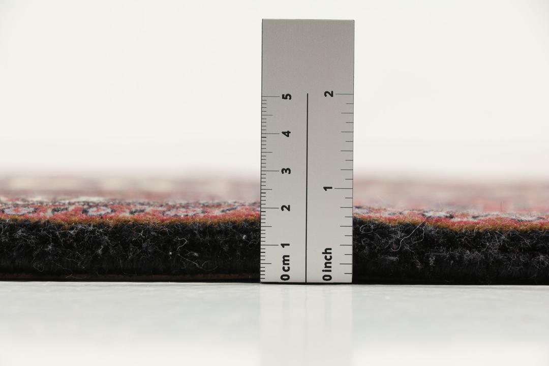 Een handgeknoopt Bidjar-tapijt uit het Midden-Oosten in donkerrood met complexe patronen.