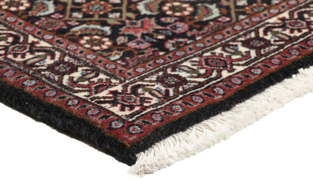 Een handgeknoopt, uniek Bidjar-tapijt uit het Midden-Oosten met een levendig rood en donkergekleurd bloemmedaillonontwerp.