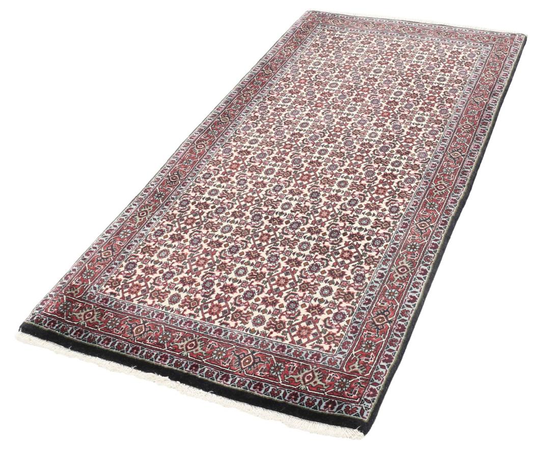 Een handgeknoopt Bidjar-tapijt uit het Midden-Oosten met een donkerrood en beige bloemenpatroon.
