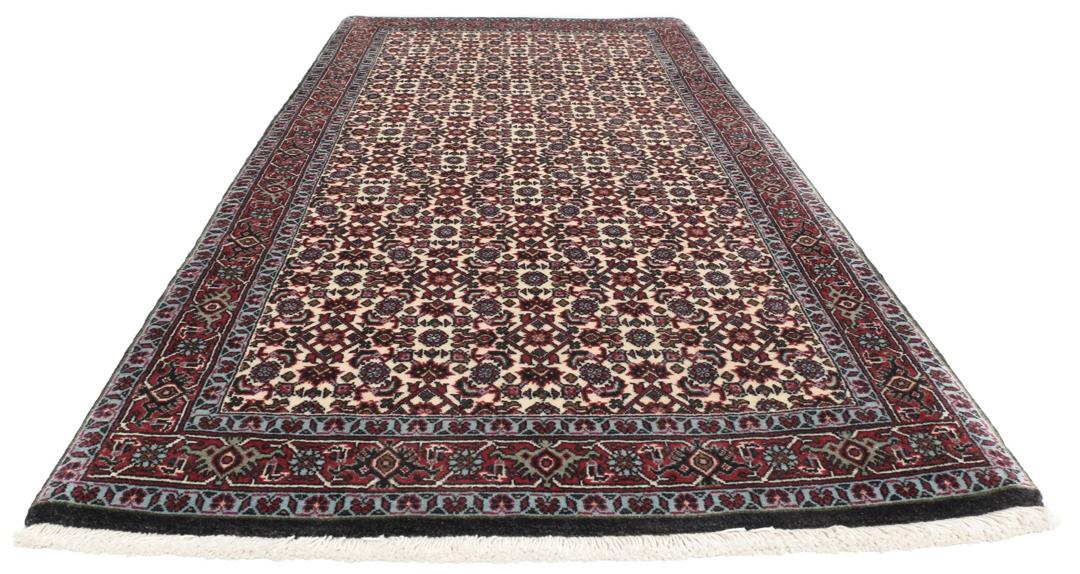 Een handgeknoopt Bidjar-tapijt uit het Midden-Oosten met een donkerrood en beige bloemenpatroon.