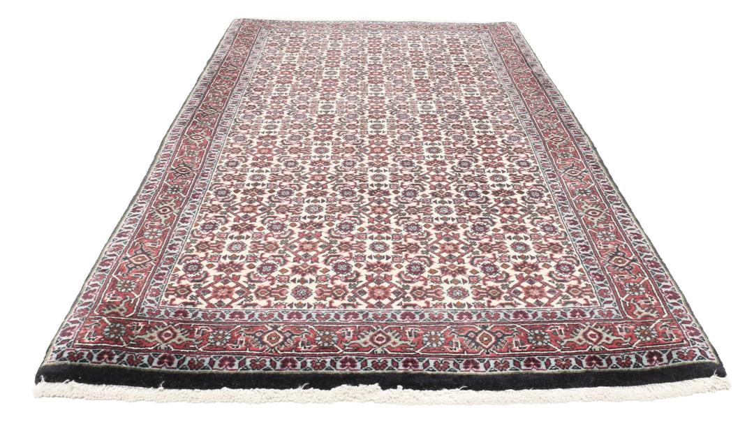 Een handgeknoopt Bidjar-tapijt uit het Midden-Oosten met een donkerrood en beige bloemenpatroon.