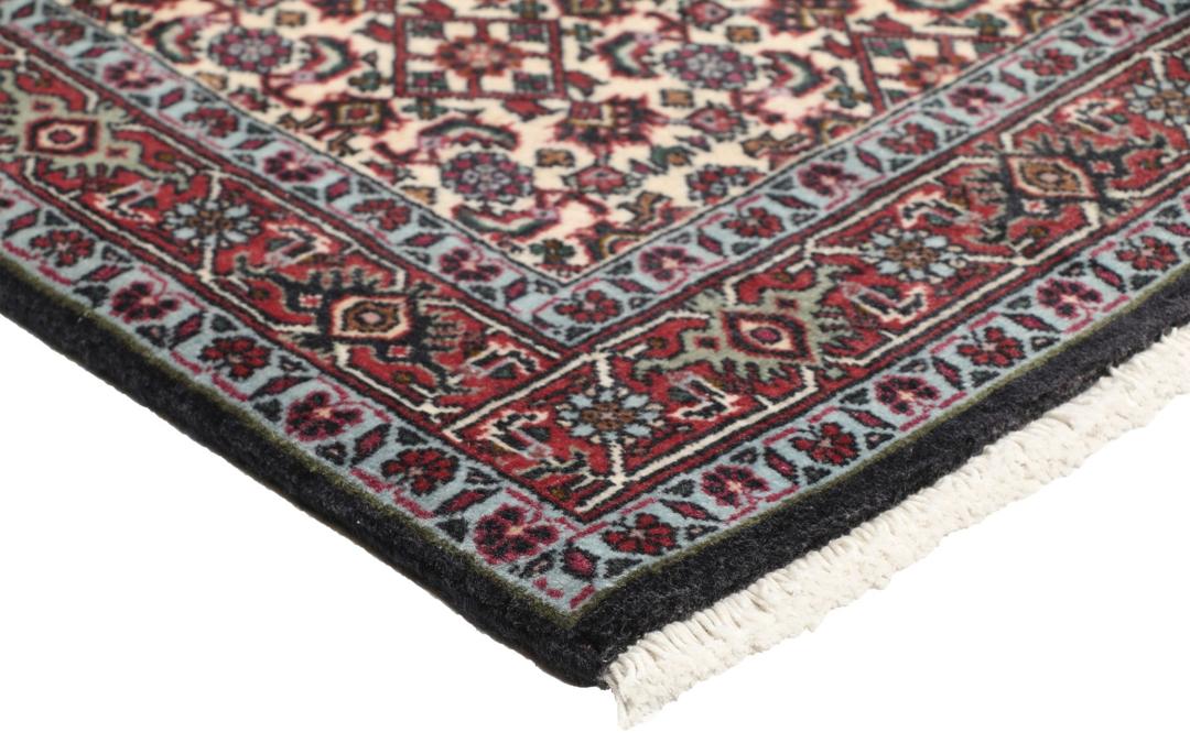 Een handgeknoopt Bidjar-tapijt uit het Midden-Oosten met een donkerrood en beige bloemenpatroon.