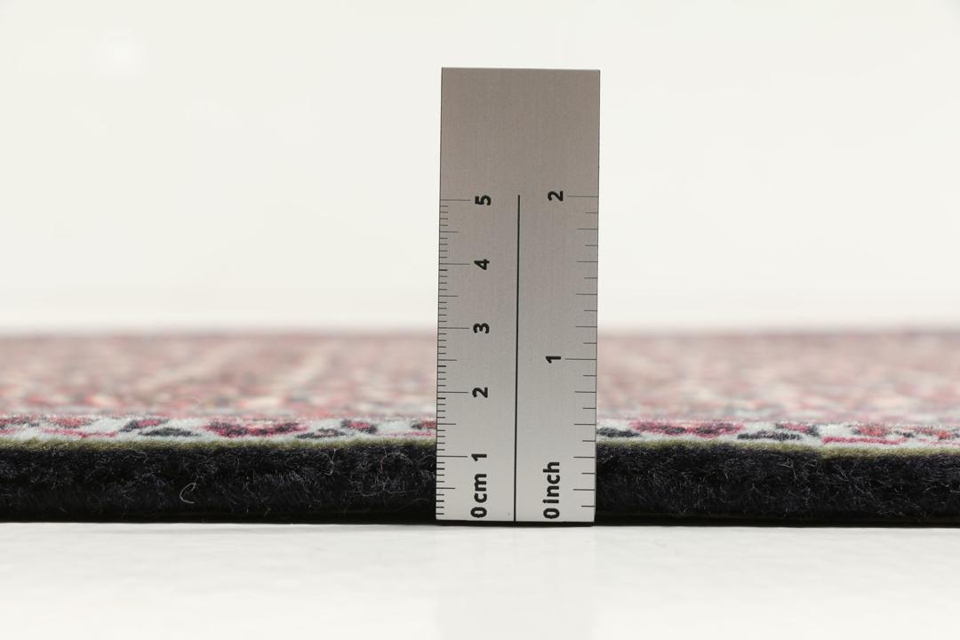 Een handgeknoopt Bidjar-tapijt uit het Midden-Oosten met een donkerrood en beige bloemenpatroon.