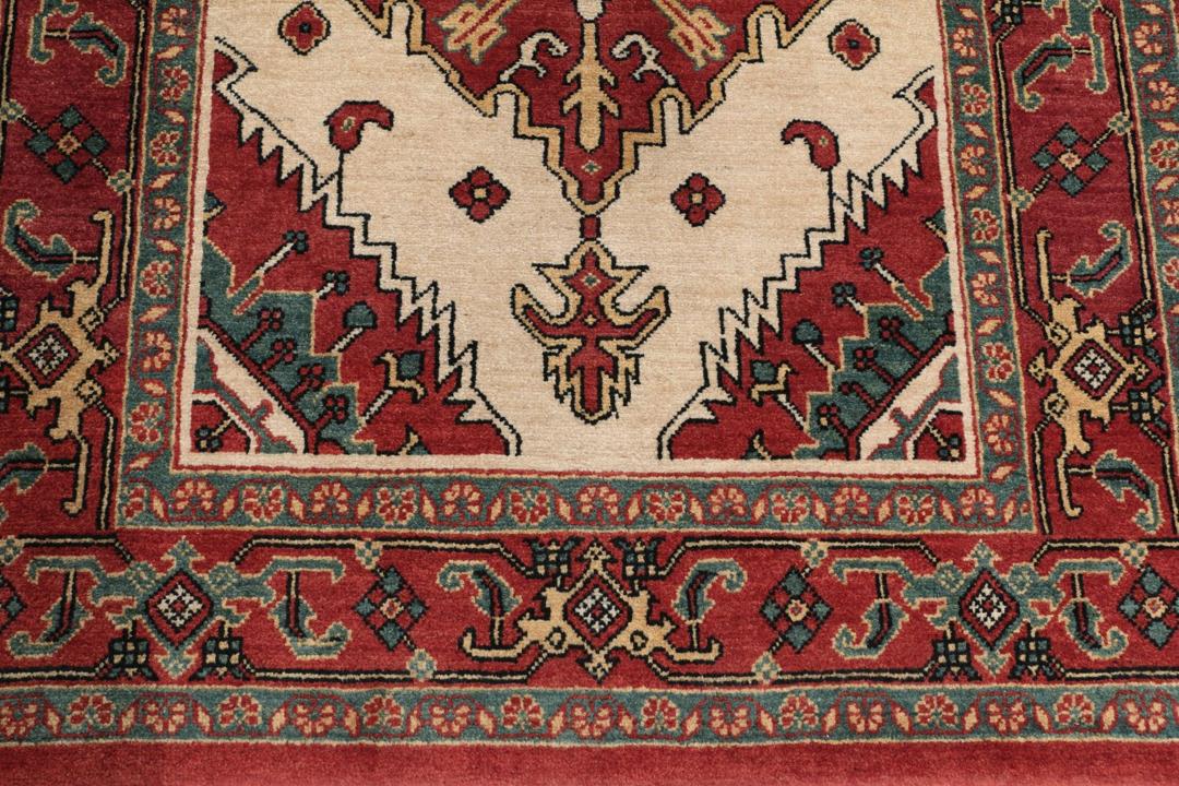Et håndknyttet Heriz-tæppe fra Mellemøsten med en levende rød og beige farvepalette.