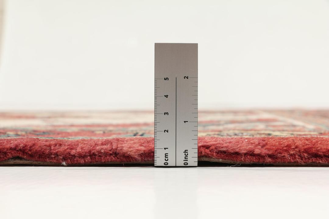 Et håndknyttet Heriz-tæppe fra Mellemøsten med en levende rød og beige farvepalette.