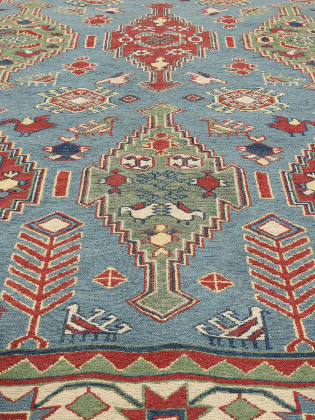 Handgeweven Afghaans Kelim-tapijt met geometrische motieven in blauwe, rode en groene tinten.