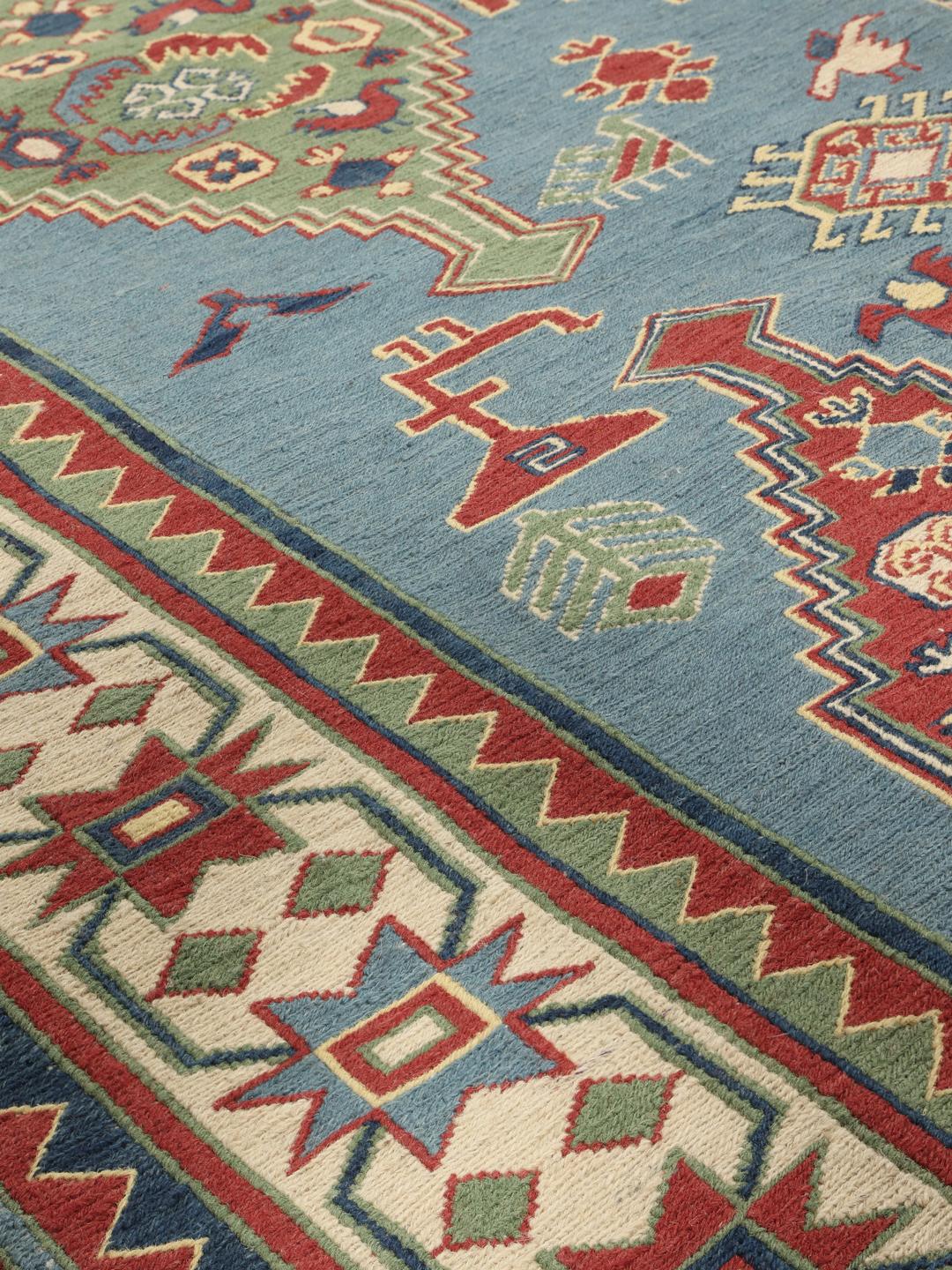 Handgeweven Afghaans Kelim-tapijt met geometrische motieven in blauwe, rode en groene tinten.