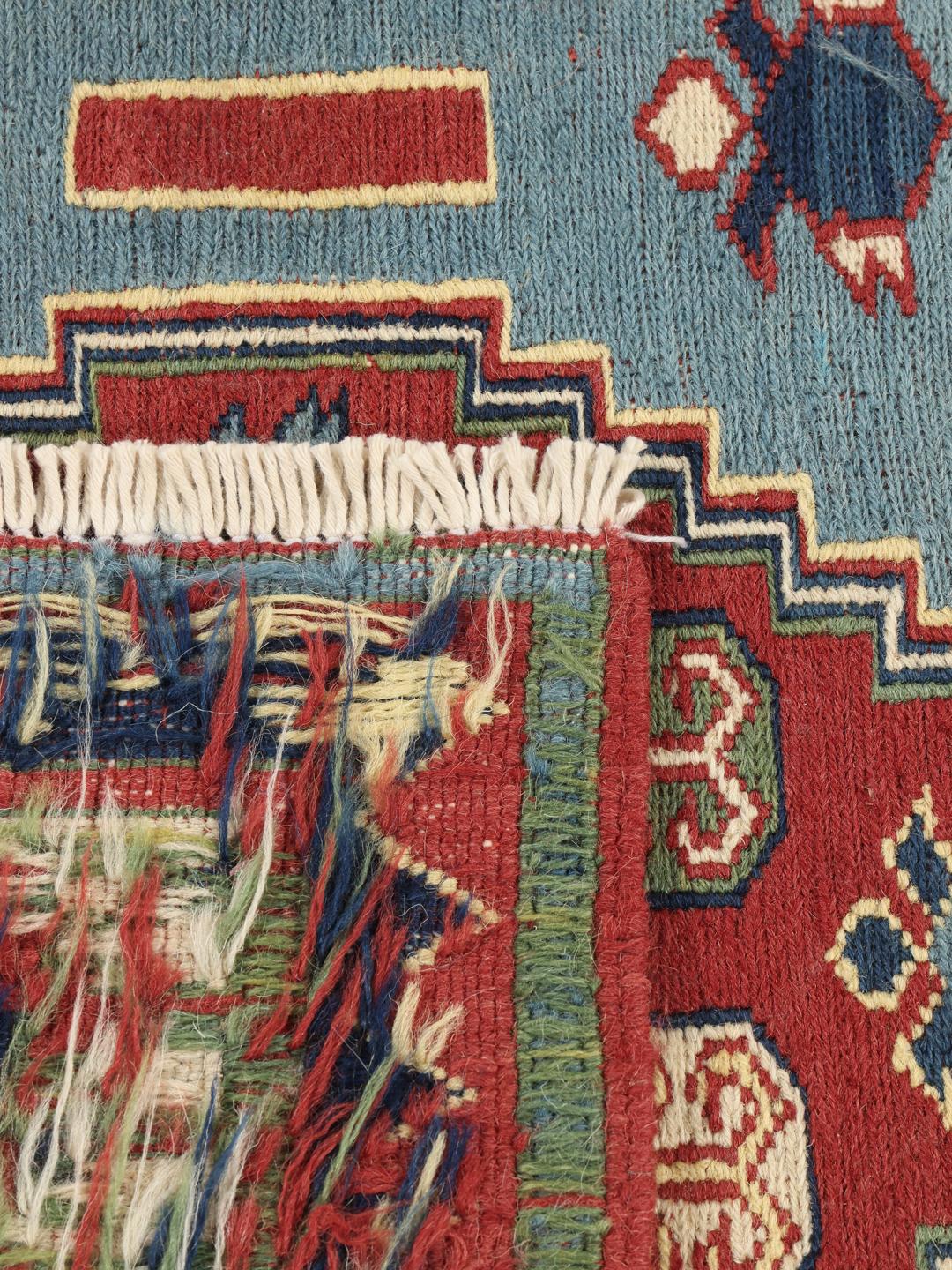 Handgeweven Afghaans Kelim-tapijt met geometrische motieven in blauwe, rode en groene tinten.