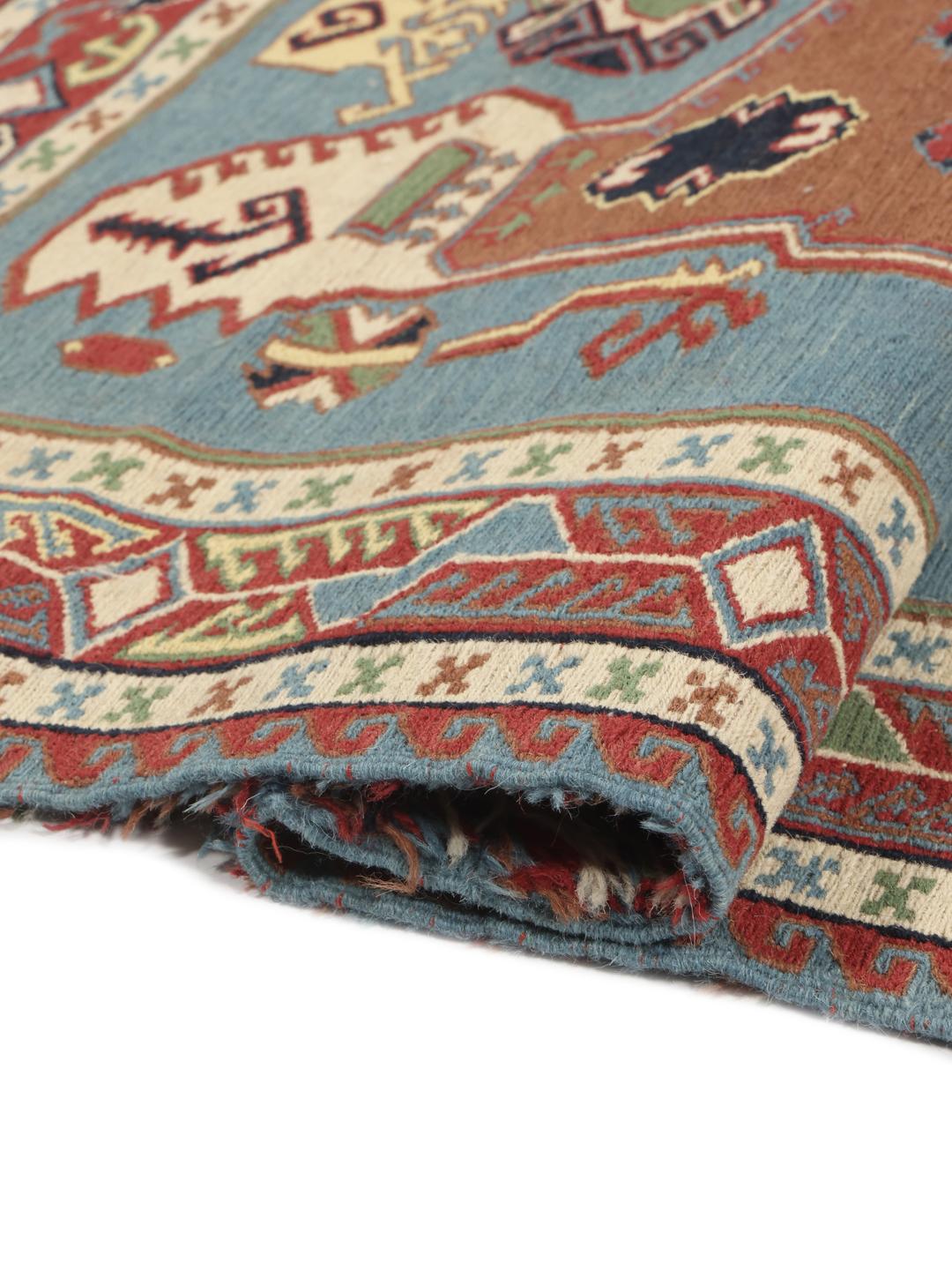 Håndvævet afghansk Kelim-tæppe med blåt felt og ornamenterede geometriske motiver.