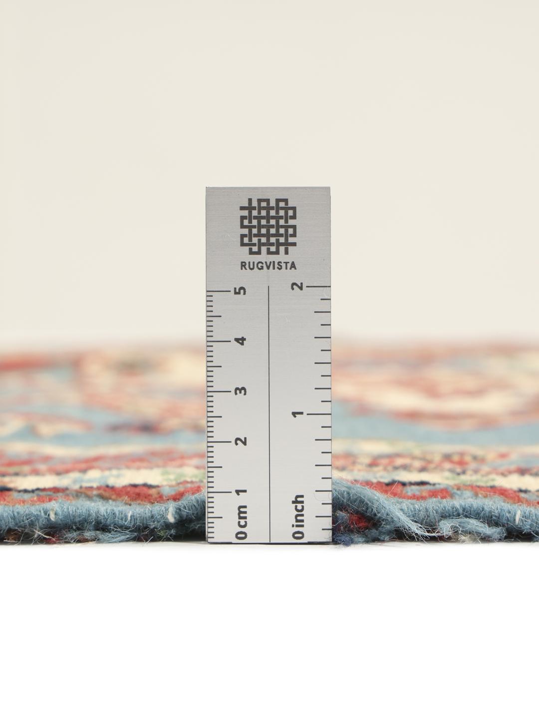 Håndvævet afghansk Kelim-tæppe med blåt felt og ornamenterede geometriske motiver.