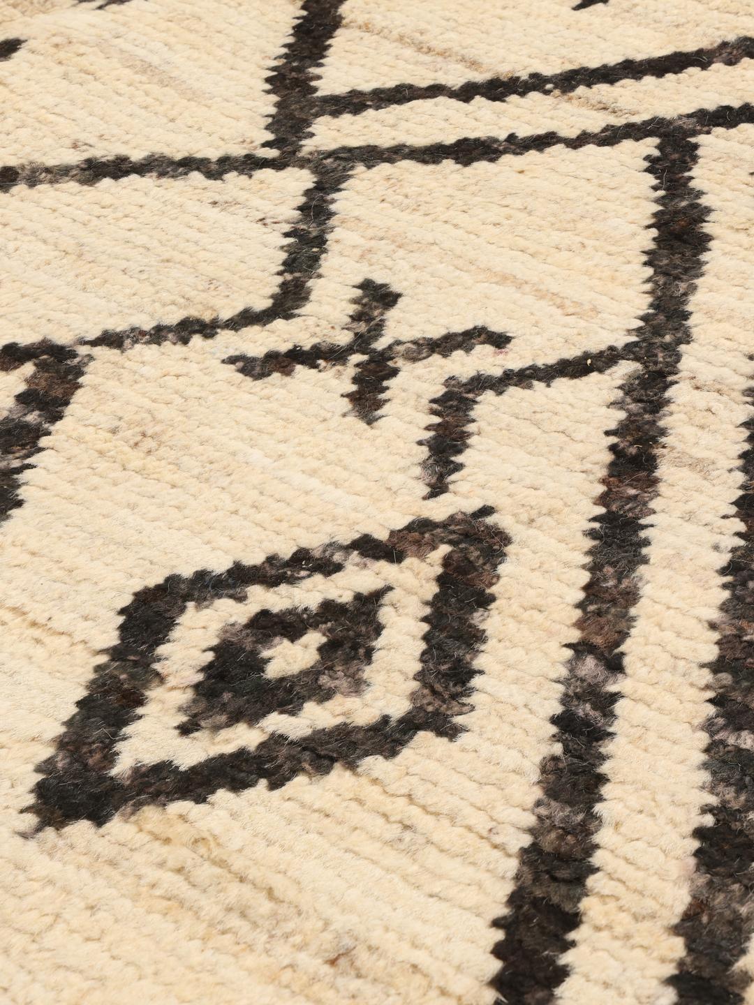 Håndknyttet tæppe fra Mellemøsten med sorte geometriske mønstre på en beige uldbaggrund