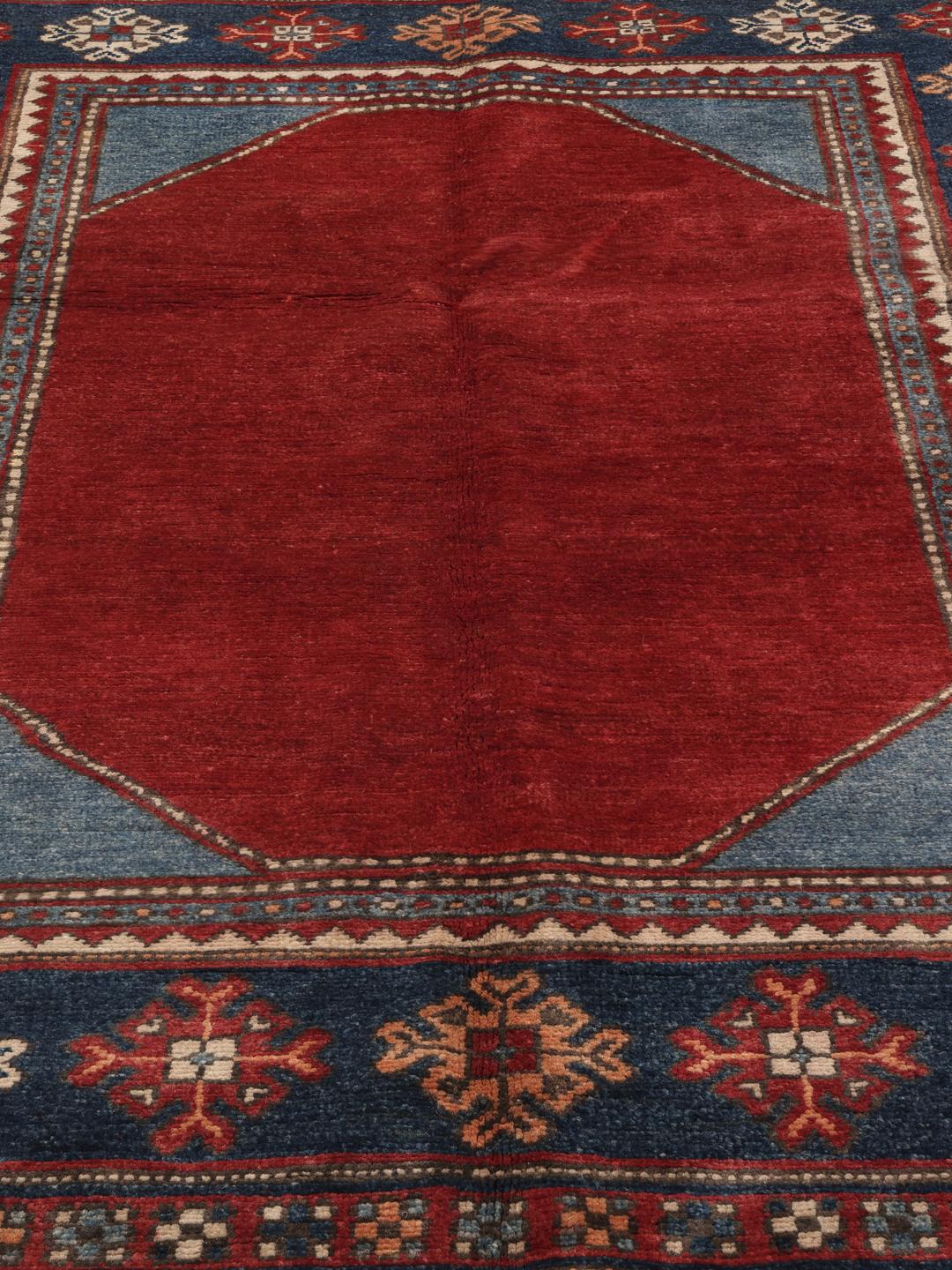 Handgefertigter afghanischer Kazak-Teppich in Rot und Blau mit traditionellen geometrischen Motiven.