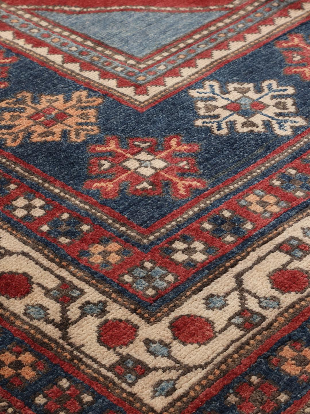 Handgefertigter afghanischer Kazak-Teppich in Rot und Blau mit traditionellen geometrischen Motiven.