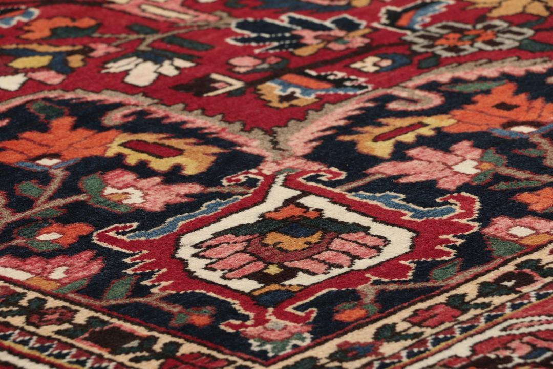 Een groot handgeknoopt Bakhtiari-tapijt uit het Midden-Oosten in donkerrode en donkerblauwe tinten.
