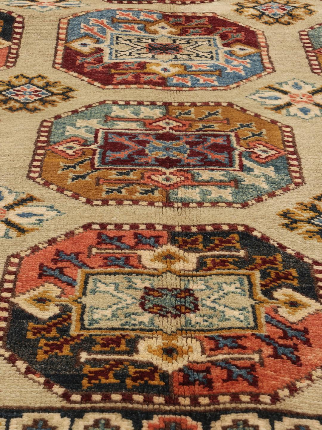 Handgeknoopt Kazak-tapijt uit Afghanistan in beige met geometrische medaillonpatronen.