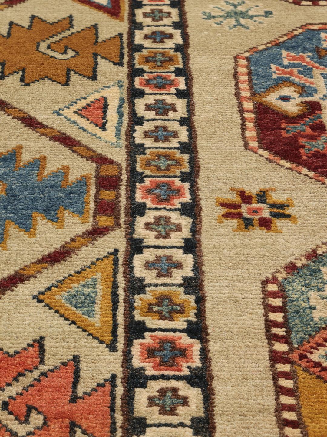 Handgeknoopt Kazak-tapijt uit Afghanistan in beige met geometrische medaillonpatronen.