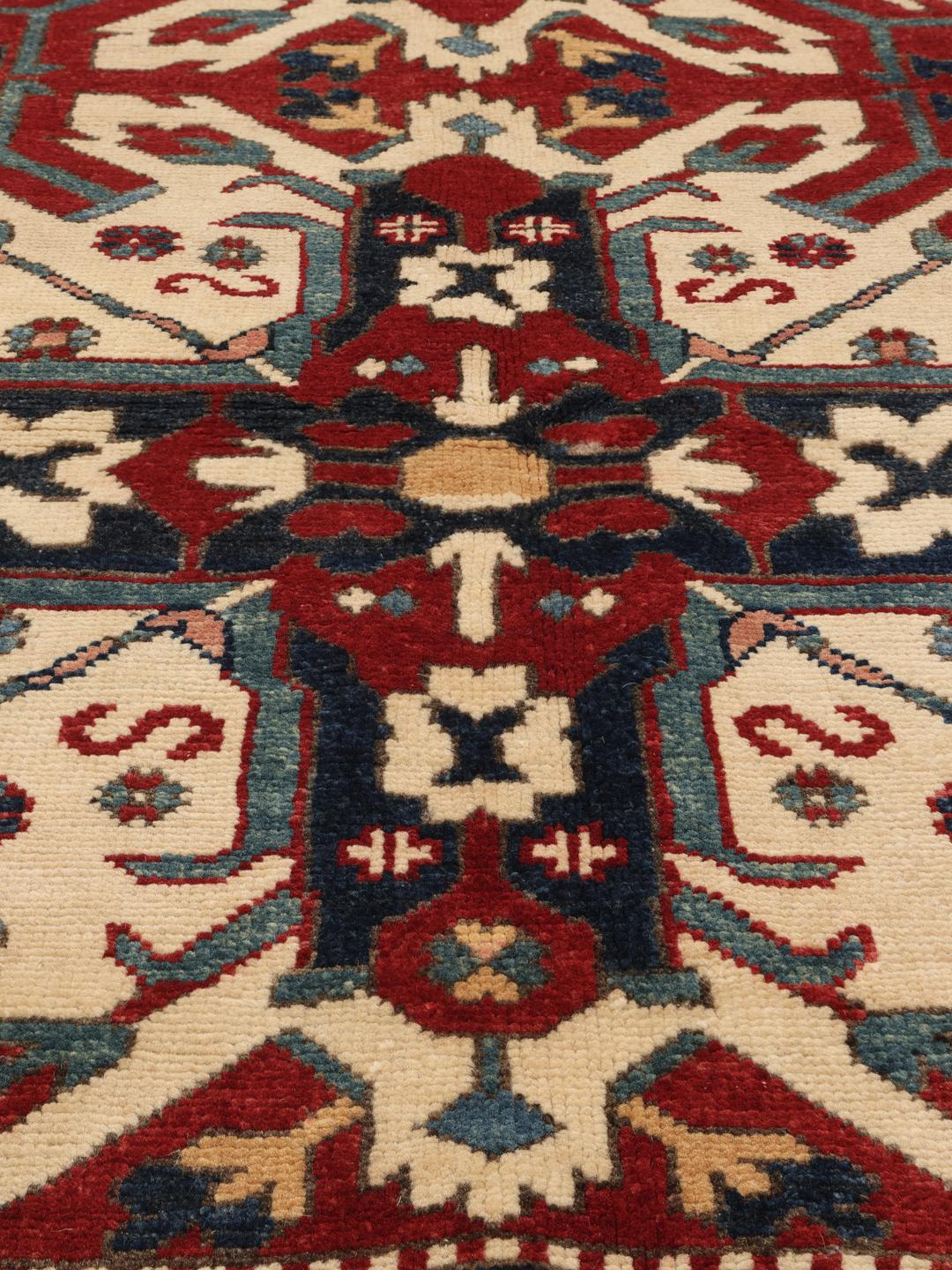 Tapis Kazak noué à la main en provenance d'Afghanistan avec un champ rouge et des motifs géométriques audacieux