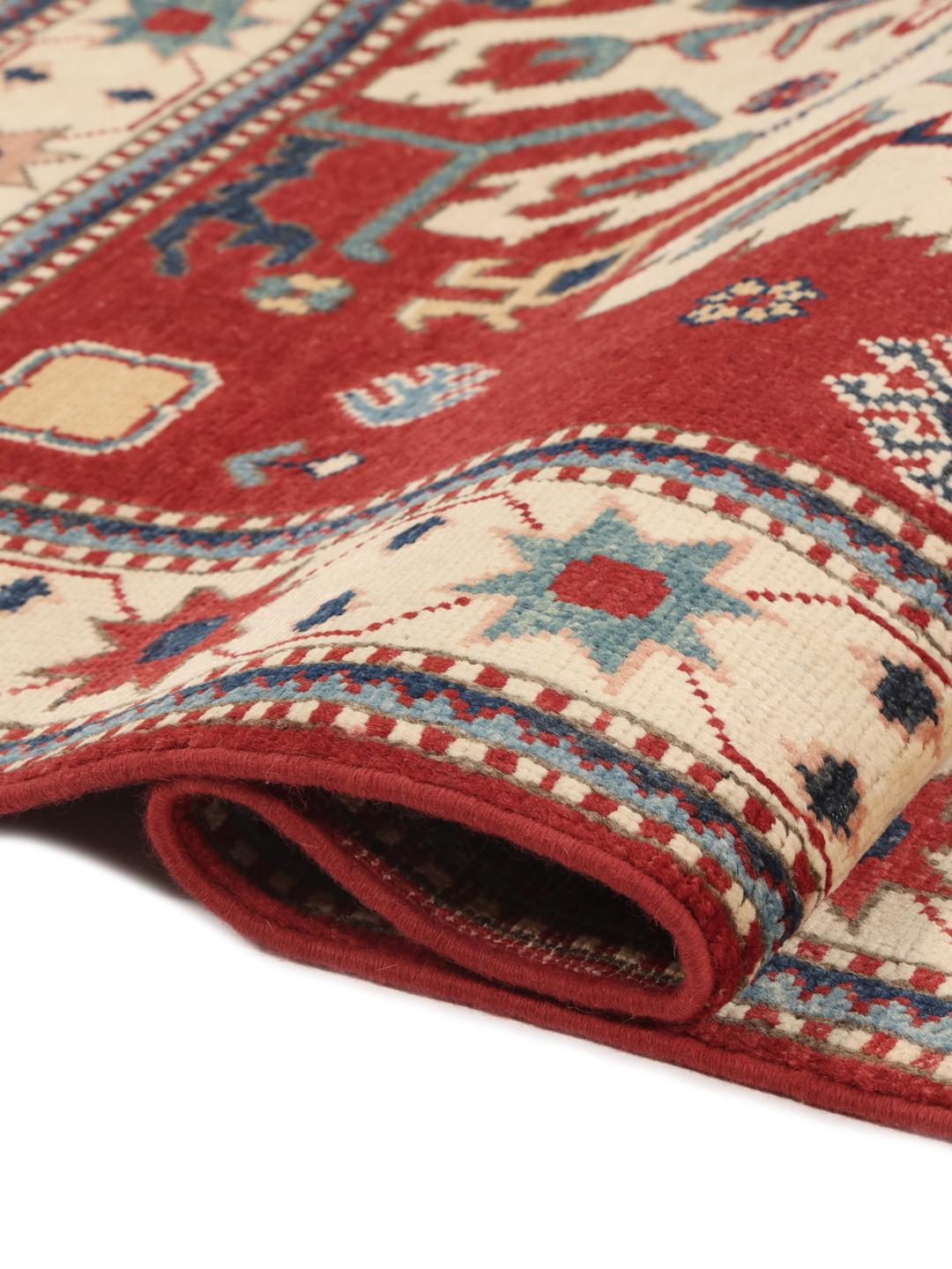 Tapis Kazak noué à la main en provenance d'Afghanistan avec un champ rouge et des motifs géométriques audacieux