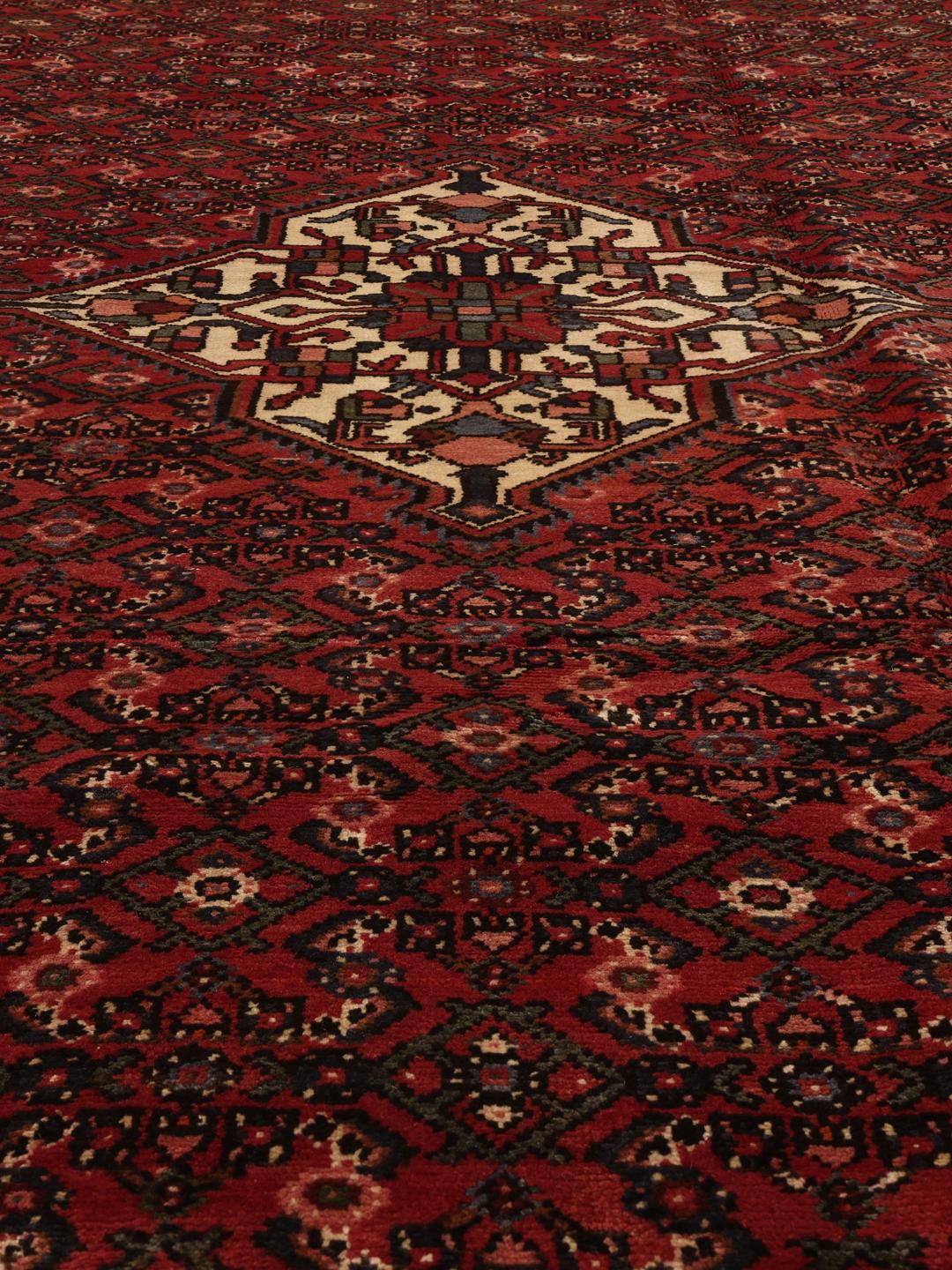 Hand-knotted Hosseinabad rug from the Middle East in deep red tones