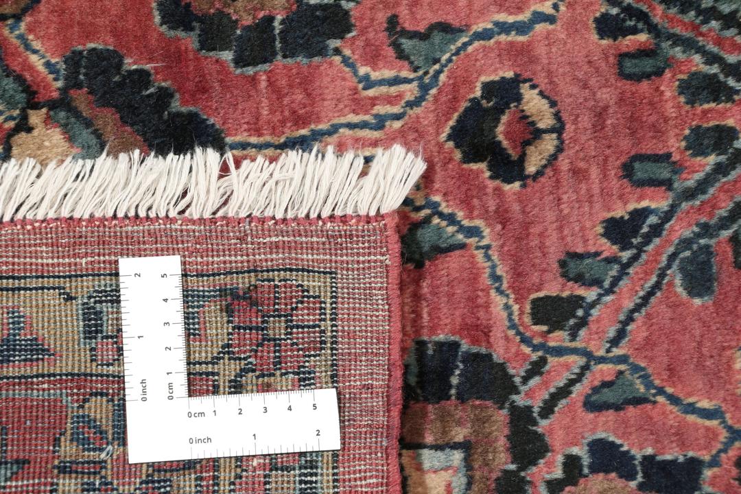 Et stort, håndknyttet Sarouk American tæppe med en dybrød bund og indviklede blomstermotiver.