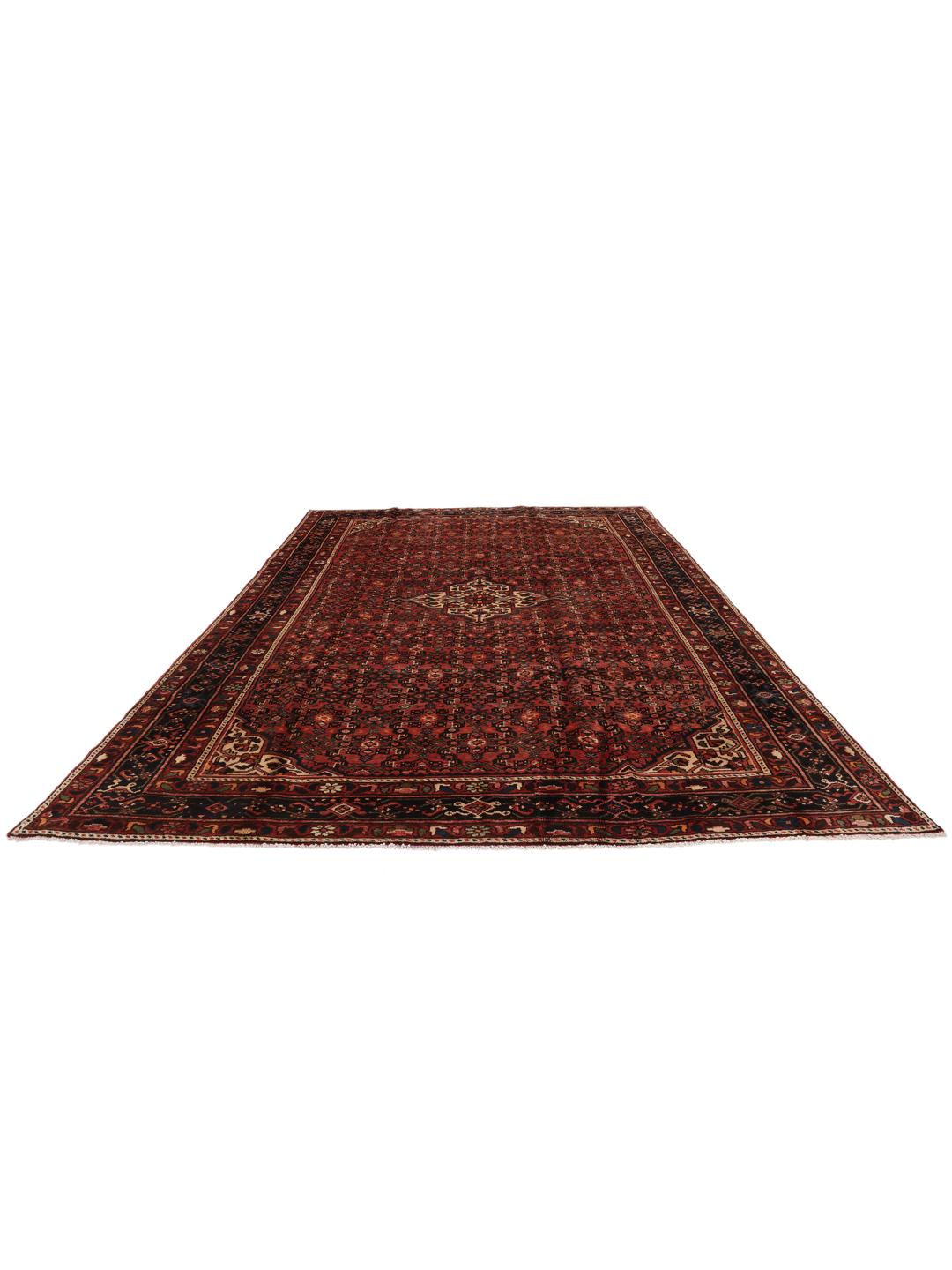 A hand-knotted Hosseinabad rug from the Middle East featuring a dark-red field and intricate patterns.